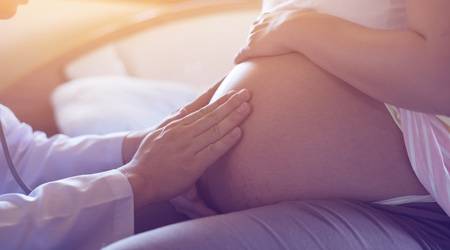 Schwangere Ärztin hält ihren Bauch