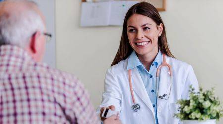 Junge Ärztin berät einen älteren Herrn