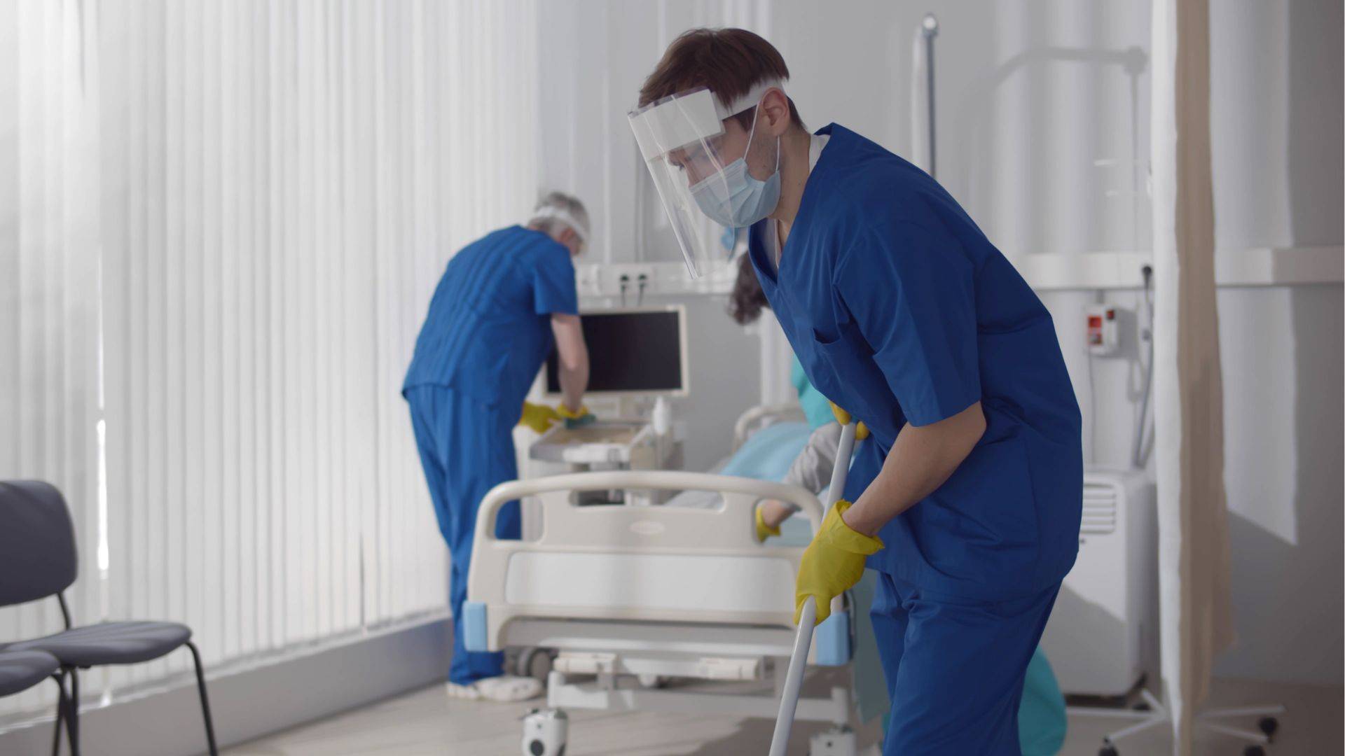 Krankenhauspersonal auchtet bei Reinigung eines Zimmers auf den Arbeitsschutz im Krankenhaus