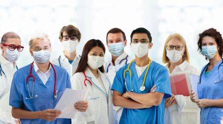 Mehrere Ärzte und Ärztinnen verschiedenen Alters stehen zusammen. s 