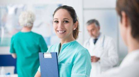 Junge Medizinstudentin will Arzt werden und hält Patientenmappe und lächelt