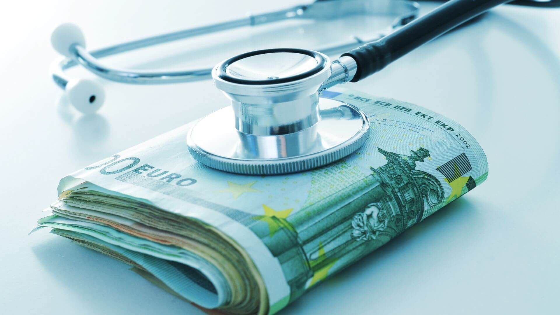 Arzt-Gehalt liegt in Bargeldscheinen auf einem Tisch mit einem Stethoskop darauf.