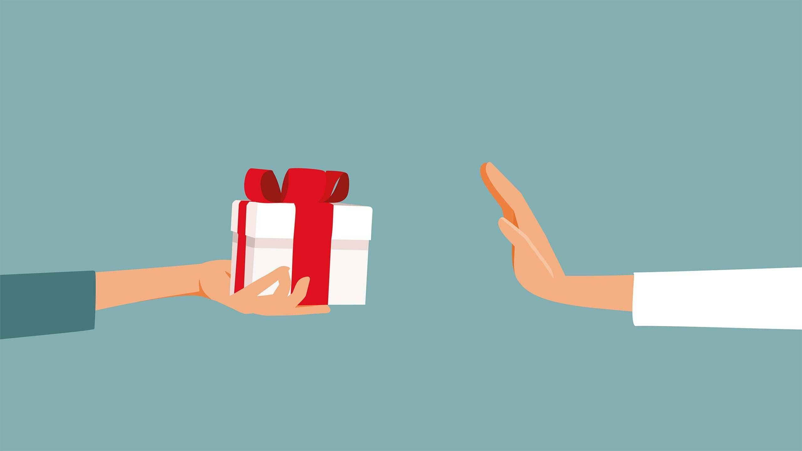 Arm in weißem Kittel lehnt Geschenk mit deutlicher Geste ab