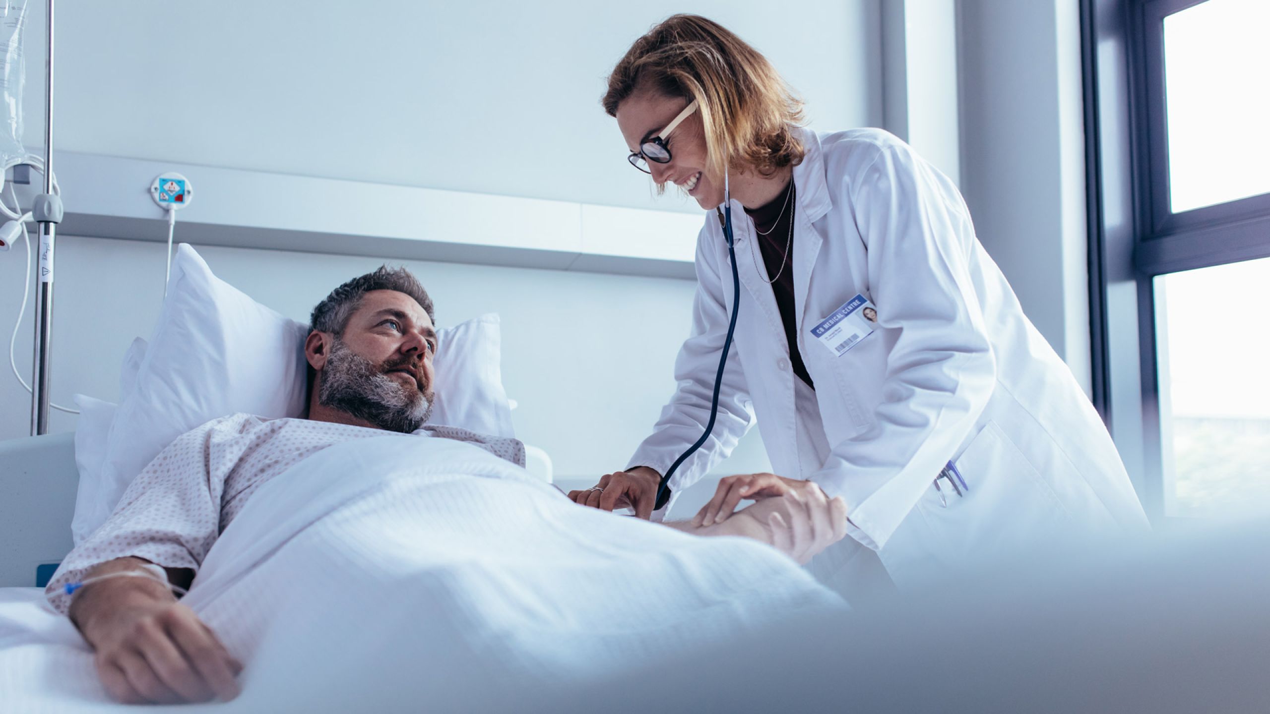 Ärztin in Teilzeit behandelt einen Patienten im Krankenhausbett