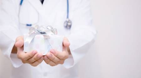 Arzt hält Geschenk in Händen