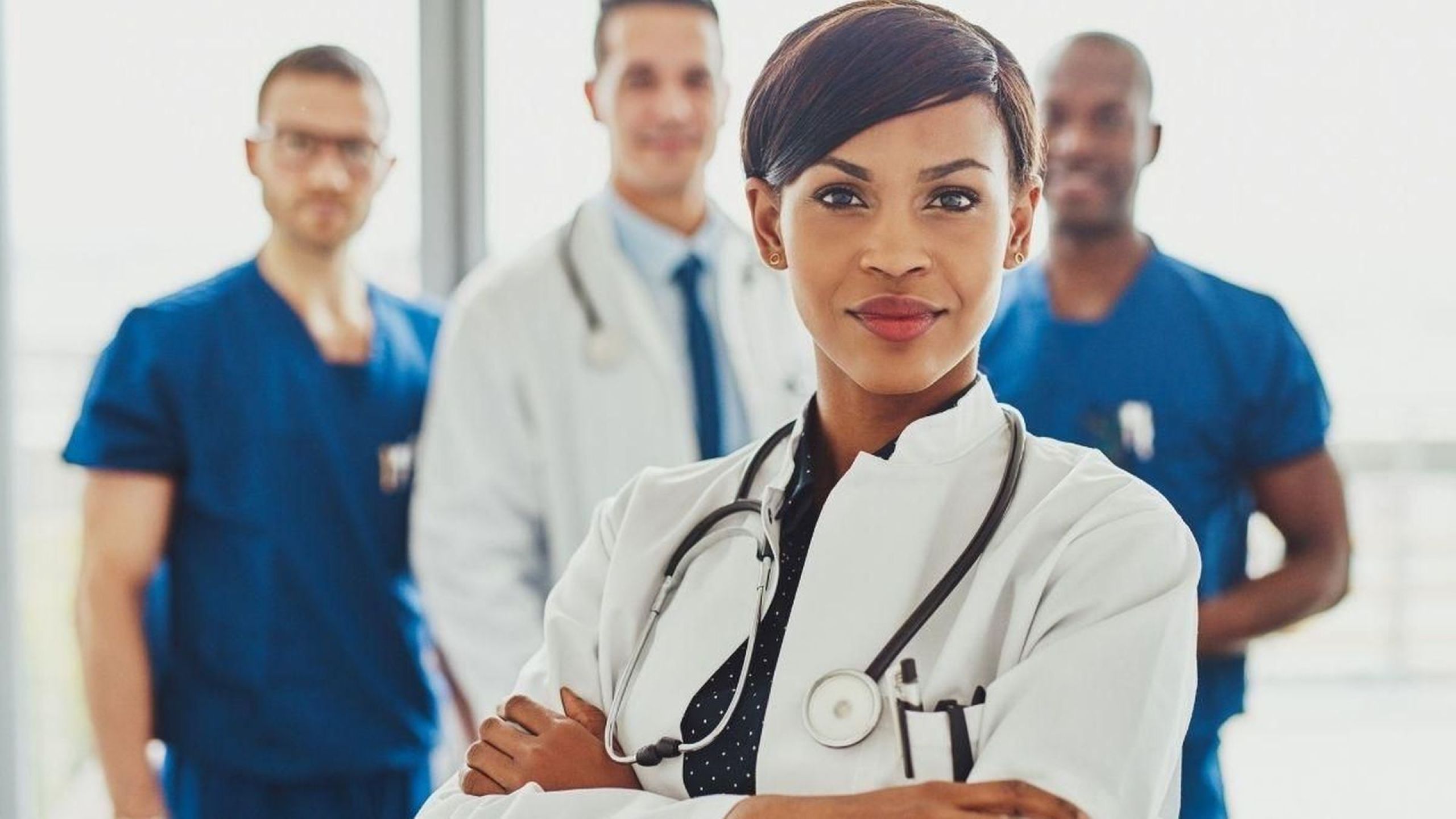 Weibliche Ärztin beweist sich als Frau in der Medizin gegenüber ihren männlichen Kollegen im Hintergrund
