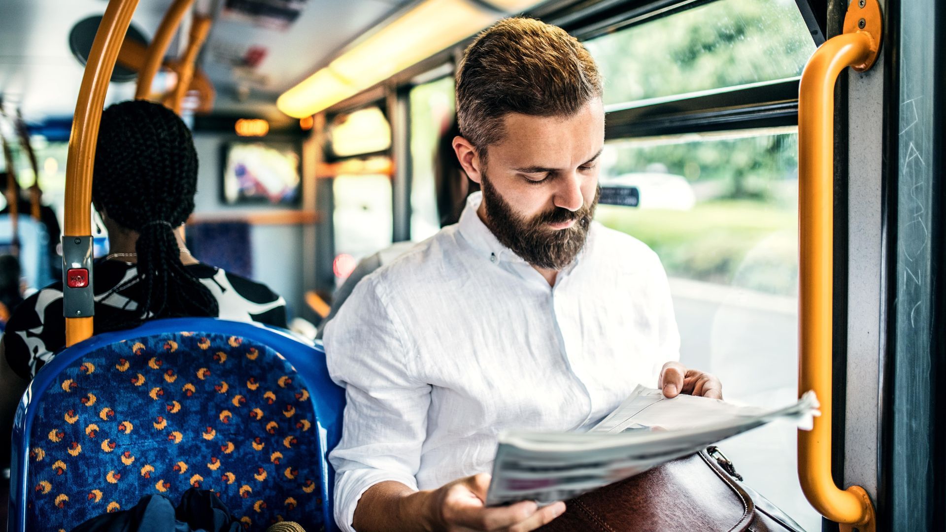 Mann liest im Bus eine Zeitschrift